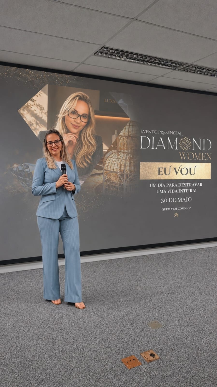 Adriana Carvalho posando ao lado do painel oficial do evento Diamond Women Curitiba